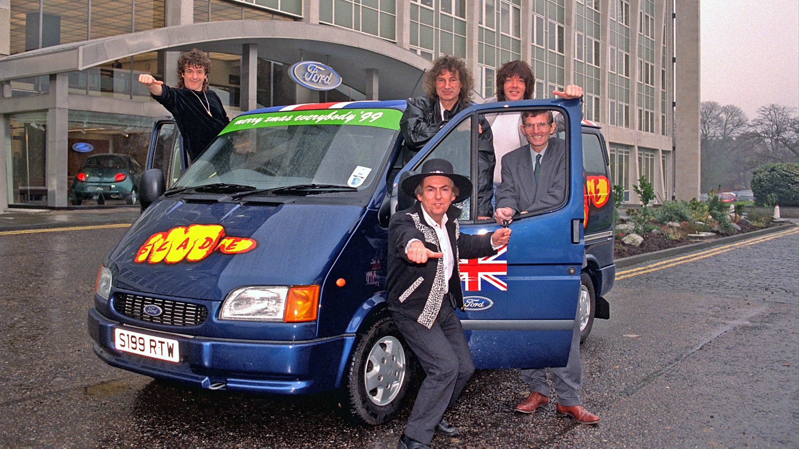 1999 – Pop band Slade collect their Transit from Ford Manager Mike Platts at Ford HQ in Brentwood.